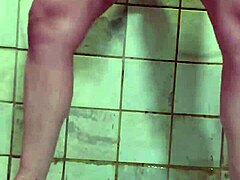 אישה מילף עם פירסינג משתמשת בדילדו כפול למשחק סולו במקלחת