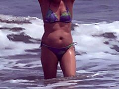 A mature woman flashes at the beach and receives unexpected ejaculation on her unshaven genitalia