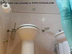 O mamă cu fundul mare este filmată pe o cameră ascunsă în timp ce face praf în baie